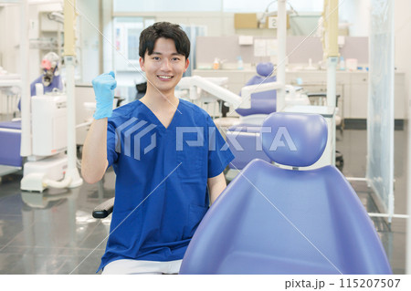 カメラ目線でガッツポーズする男性歯科医師 115207507