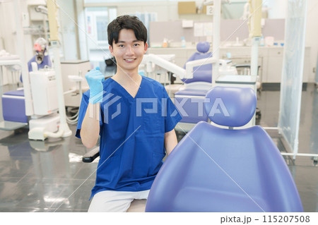 カメラ目線でガッツポーズする男性歯科医師 115207508