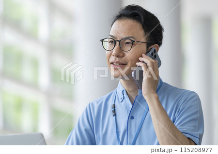 スマートフォンで通話する施設職員　イメージ 115208977