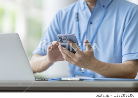 スマートフォンを操作する施設職員の手元　イメージ 115209106