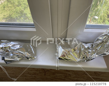 Food foil lies on the windowsill in the house 115210778