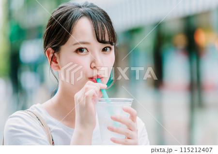 屋外で水を飲む若い女性 115212407