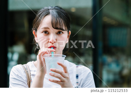 屋外で水を飲む若い女性 屋外で水を飲む若い女性 115212533