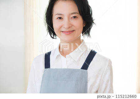 キッチンに立つミドル女性のポートレート キッチンに立つミドル女性のポートレート 115212660