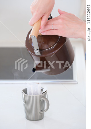 ドリップコーヒーにお湯を注ぐミドル女性の手 115212661