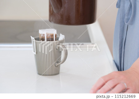 ドリップコーヒーにお湯を注ぐミドル女性の手 ドリップコーヒーにお湯を注ぐミドル女性の手 115212669