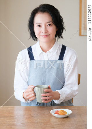 リビングで午後のひとときを過ごすミドル女性 115212673
