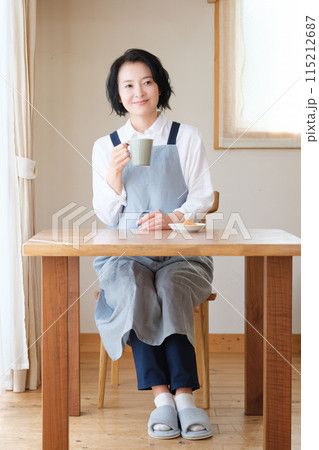 リビングで午後のひとときを過ごすミドル女性 リビングで午後のひとときを過ごすミドル女性 115212687