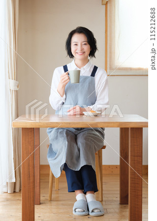 リビングで午後のひとときを過ごすミドル女性 115212688