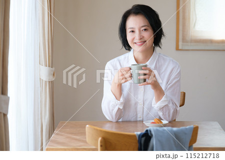 リビングで午後のひとときを過ごすミドル女性 115212718