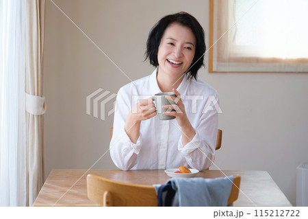 リビングで午後のひとときを過ごすミドル女性 リビングで午後のひとときを過ごすミドル女性 115212722