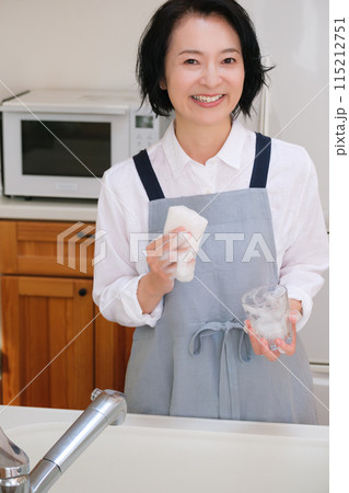 キッチンでコップを洗うミドル女性 115212751