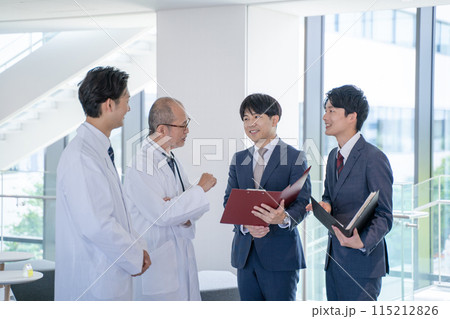 病院で笑顔で会話する男性医師と医薬情報担当者MR 115212826