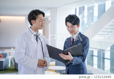 病院で笑顔で会話する男性医師と医薬情報担当者MR 病院で笑顔で会話する男性医師と医薬情報担当者MR 115212840