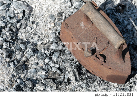 Rare iron working on coals. Against the background of extinct coals. 115213831
