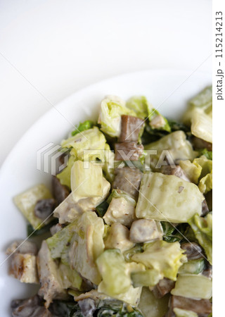 Salad with herbs and meat on a white plate. Delicious salad with mayonnaise and mushrooms. Salad with herbs and meat on a white plate. Delicious salad with mayonnaise and mushrooms. 115214213