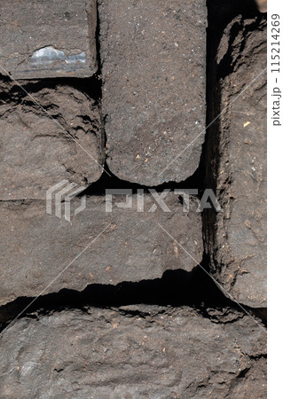 Briquette peat stacked nearby. Close-up. View from above. 115214269