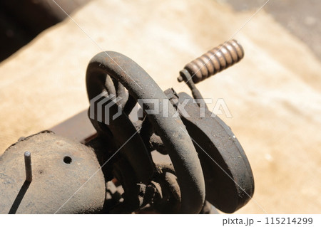 Old sewing machine, with manual drive. Covered with corrosion, dust and cobwebs. It stands on a coarse cloth. Old sewing machine, with manual drive. Covered with corrosion, dust and cobwebs. It stands on a coarse cloth. 115214299