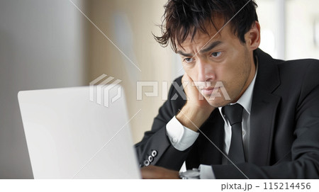 ノートパソコンを使う悩むビジネスマン 115214456