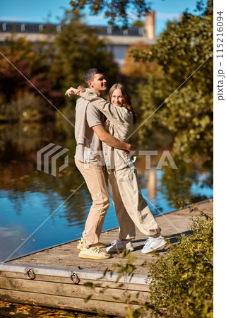 A happy couple in love in casual clothes travel together, hike and have fun in the fall forest on a weekend in nature in autumn outdoors, selective focus. COUPLE LOVE STORY park pond lake. Handsome A happy couple in love in casual clothes travel together, hike and have fun in the fall forest on a weekend in nature in autumn outdoors, selective focus. COUPLE LOVE STORY park pond lake. Handsome 115216094