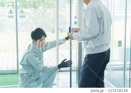 自動ドアのメンテナンスをする作業員 115218130