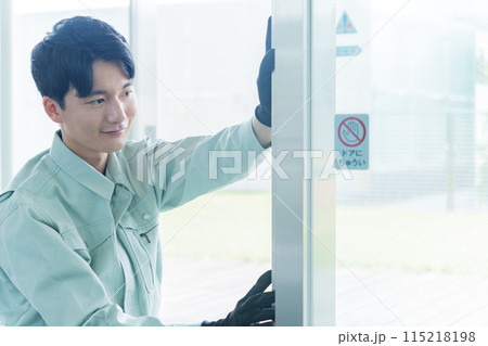 自動ドアのメンテナンスをする作業員 自動ドアのメンテナンスをする作業員 115218198