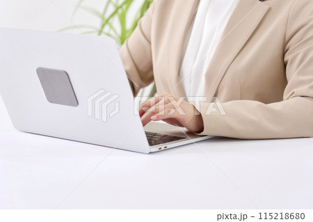 オフィスでパソコンを使ってデスクワークをする若いビジネスウーマン 顔無し オフィスでパソコンを使ってデスクワークをする若いビジネスウーマン 顔無し 115218680