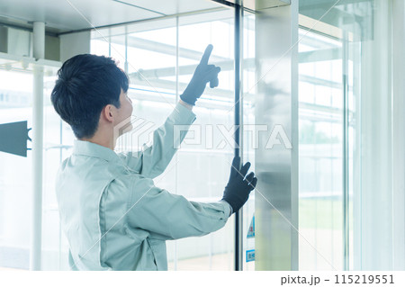 自動ドアを点検する作業員 115219551