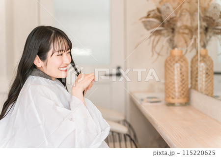 美容室でヘアドネーションのために自分で髪の毛を切る若い女性客 美容室でヘアドネーションのために自分で髪の毛を切る若い女性客 115220625