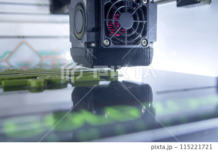 3D printer printing a model. Equipment of a 3D printer during the process of printing a model from molten plastic 115221721