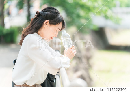 外出中に脱水症状・熱中症で目眩・立ちくらみ・体調不良になるアジア人女性ビジネスウーマン 115222502