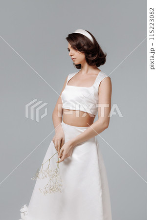 Woman in a white wedding dress with a sprig of gypsophila flowers 115223082