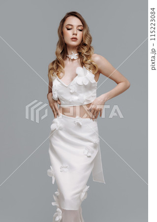 A woman in a wedding dress is holding a bouquet of flowers 115223084