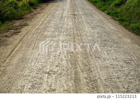 The Dirt Road is Rough and Full of Potholes, Marking the Entrance to a Poor Rural Village The Dirt Road is Rough and Full of Potholes, Marking the Entrance to a Poor Rural Village 115223213