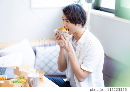 デリバリーで注文した料理を食べる男性 デリバリーで注文した料理を食べる男性 115223326
