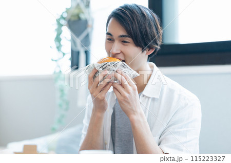 デリバリーで注文した料理を食べる男性 デリバリーで注文した料理を食べる男性 115223327
