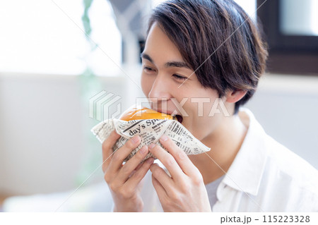 デリバリーで注文した料理を食べる男性 115223328