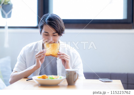 食パンを食べる男性 115223762
