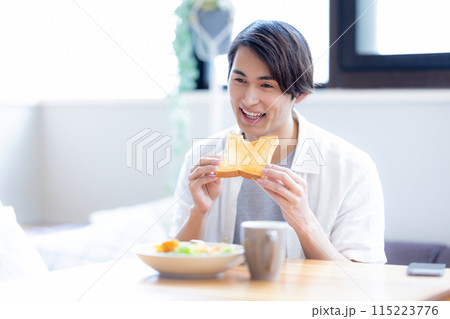 食パンを食べる男性 115223776