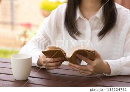 オープンカフェで本を読む若い女性 オープンカフェで本を読む若い女性 115224781