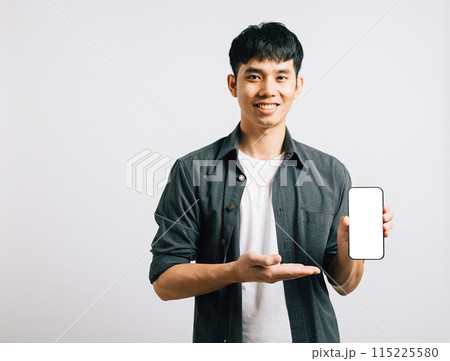 Portrait Asian smiling young man show mobile phone blank screen and hand open studio shot isolated white background, Happy excited lifestyle men hold smartphone present something on palm and screen Portrait Asian smiling young man show mobile phone blank screen and hand open studio shot isolated white background, Happy excited lifestyle men hold smartphone present something on palm and screen 115225580