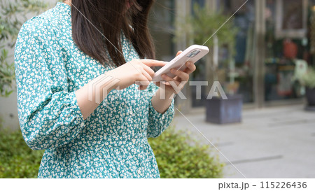 街角でスマホを使用する若い女性 街角でスマホを使用する若い女性 115226436