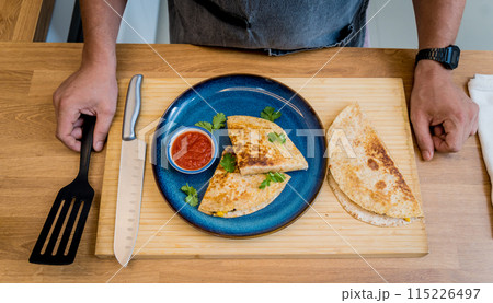 Chef at the kitchen preparing quesadillas with tofu and sweet corn 115226497