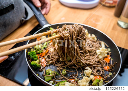 Chef at the kitchen preparing japanese buckwheat pasta with lentils 115226532
