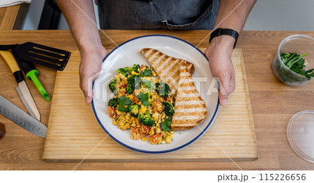 Chef at the kitchen preparing tofu scramble with vegetables 115226656