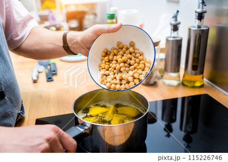 Chef at the kitchen preparing chickpea porridge with ginger 115226746