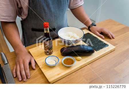 Chef at the kitchen preparing grilled eggplants with garlic Chef at the kitchen preparing grilled eggplants with garlic 115226770