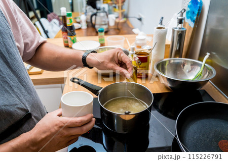 Chef at the kitchen preparing rice porridge with onion and sesame seeds Chef at the kitchen preparing rice porridge with onion and sesame seeds 115226791
