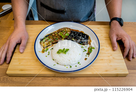 Delicious grilled eggplants with garlic on the white plate Delicious grilled eggplants with garlic on the white plate 115226904