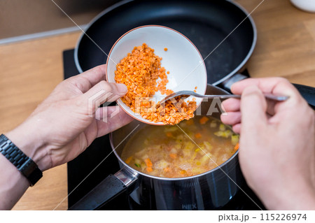 Chef at the kitchen preparing lentils soup with cauliflower and broccoli 115226974